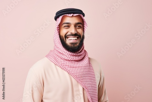 Portrait of a handsome arabian man smiling over pink background