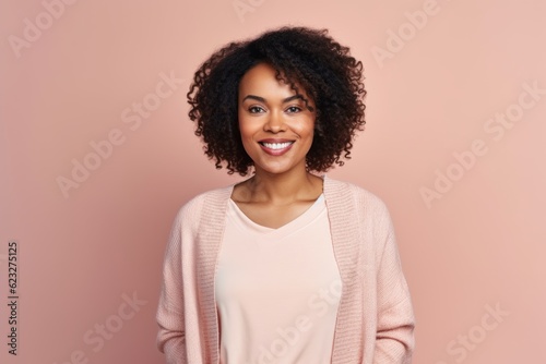 Portrait of smiling african american woman looking at camera isolated on pink background