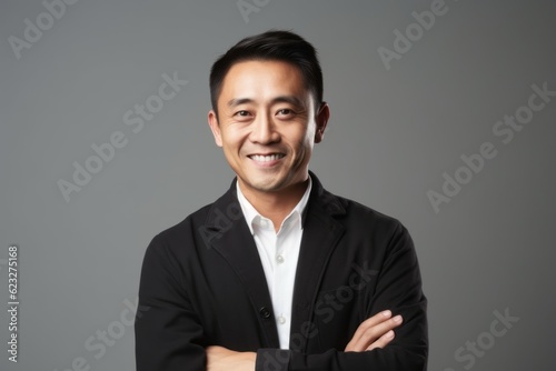 Medium shot portrait photography of a satisfied Chinese man in his 40s wearing a chic cardigan against a minimalist or empty room background 