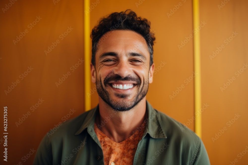 Portrait of a smiling man standing in front of a yellow wall Portrait of a smiling man standing in front of a yellow wall