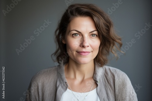 Portrait of smiling woman looking at camera, isolated on grey background