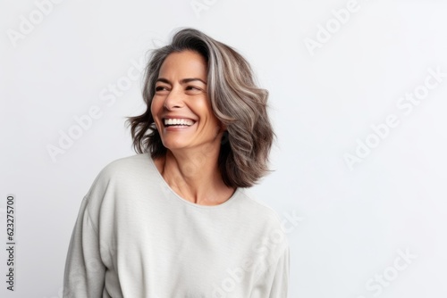 Portrait of happy middle-aged woman with grey hair laughing and looking at camera isolated over white background
