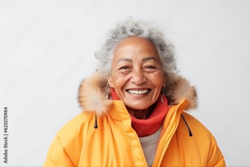 Portrait of a smiling senior asian woman wearing winter jacket standing isolated over white background