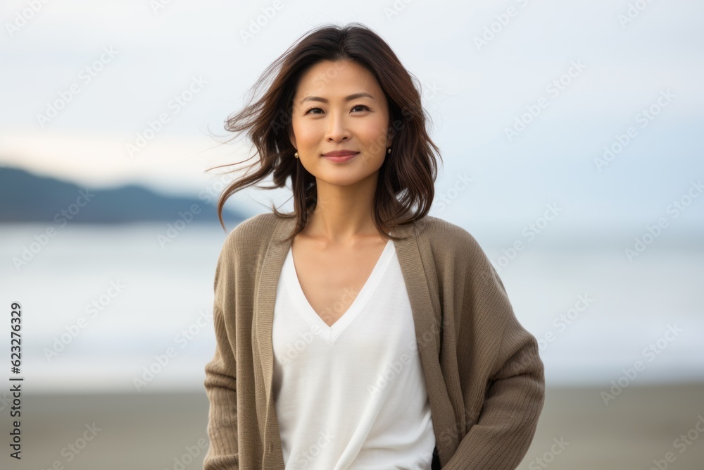 Portrait of young beautiful Asian woman smiling on the beach. She is wearing casual clothes. Portrait of young beautiful Asian woman smiling on the beach. She is wearing casual clothes.