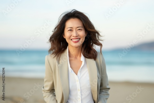 Portrait of a beautiful asian businesswoman smiling at the beach