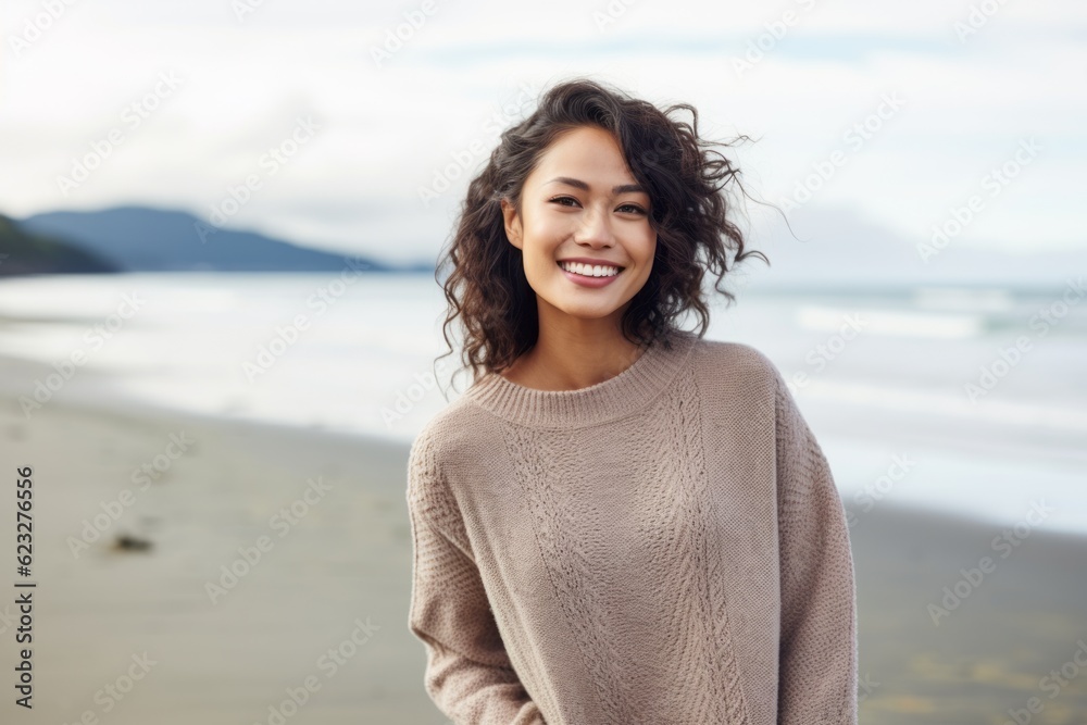 Portrait of smiling young woman standing on beach and looking at camera Portrait of smiling young woman standing on beach and looking at camera