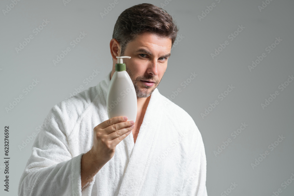 Cosmetic beauty products. Beauty man with cosmetic bottle. Natural cosmetics cream for man. Spa beauty products. Man advertising new cosmetic product, promoting cosmetics. Cosmetic beauty products. Beauty man with cosmetic bottle. Natural cosmetics cream for man. Spa beauty products. Man advertising new cosmetic product, promoting cosmetics.