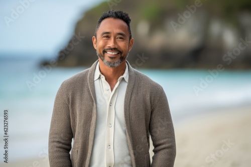 Portrait of happy mature man standing on beach at the day time