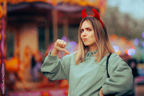 Fotografie Mean Selfish Woman Wearing Devil Horns Pointing to Herself