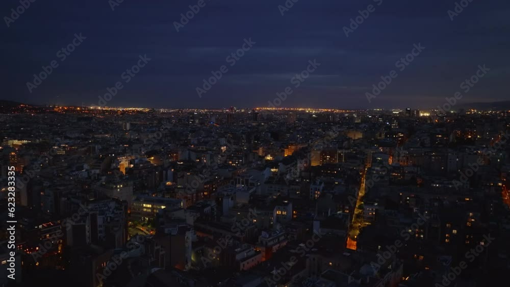 Aerial ascending shot of metropolis at night. Revealing buildings and streets and light glowing into dark in background. Barcelona, Spain Aerial ascending shot of metropolis at night. Revealing buildings and streets and light glowing into dark in background. Barcelona, Spain