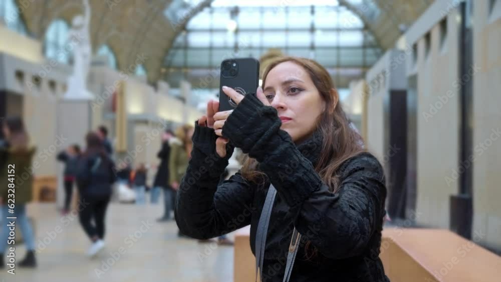 Thoughtful Latina woman tourist with smartphone looking up and enjoying view in Orsay Museum in Paris, France while relaxing on weekend Thoughtful Latina woman tourist with smartphone looking up and enjoying view in Orsay Museum in Paris, France while relaxing on weekend