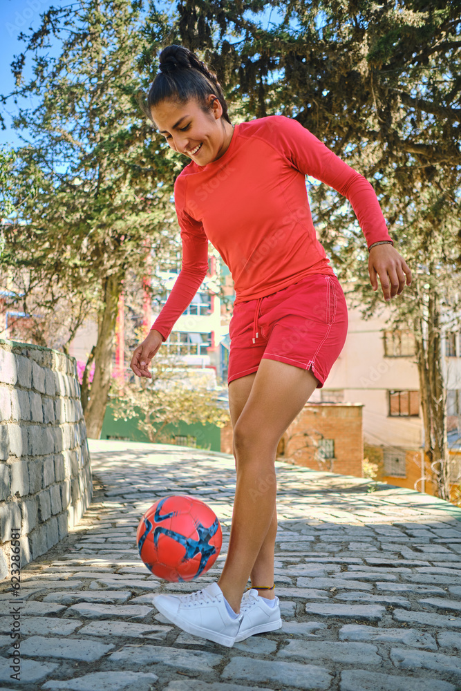 vertical photo of a young woman playing soccer with a ball in bolivia latin america vertical photo of a young woman playing soccer with a ball in bolivia latin america
