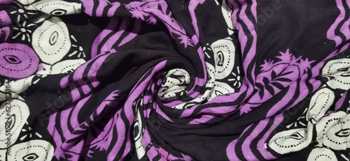 A photo of a patterned cloth with black, purple and white base colors suitable for the background of your business products