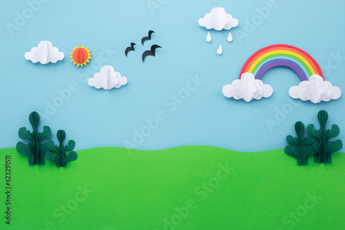 Paper art landscape background. blue sky with rainbow and green tree made of paper cut. creative minimal concept.