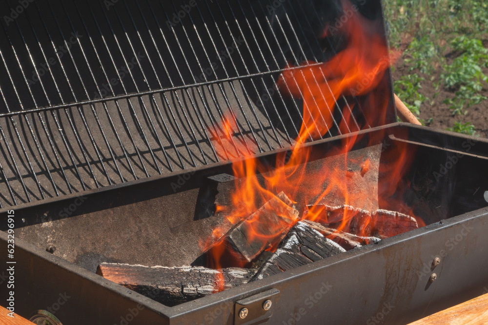 Firewood is burned in the barbecue to prepare coals for roasting meat Firewood is burned in the barbecue to prepare coals for roasting meat