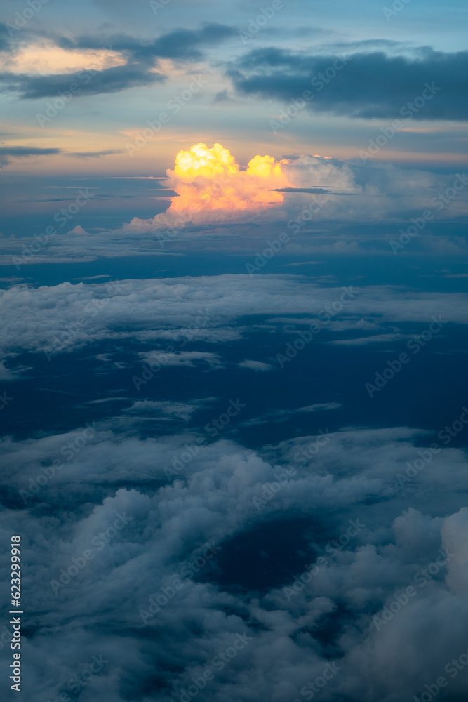 Bright Yellow Explosion-Like Cloud Surrounded by Majestic Colorful Cloudscape at Twilight From an Airplane Window over Costa Rica