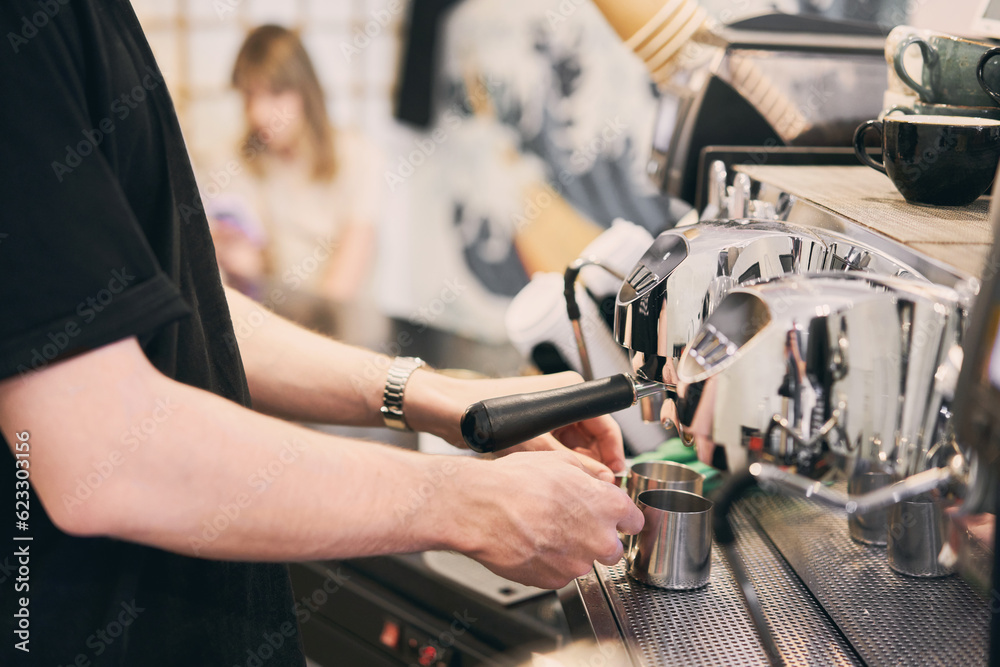 A small coffee business. Makes espresso, Americano with a takeaway. A professional barista prepares coffee in a carob coffee machine. Favorite job in the restaurant industry. A small coffee business. Makes espresso, Americano with a takeaway. A professional barista prepares coffee in a carob coffee machine. Favorite job in the restaurant industry.