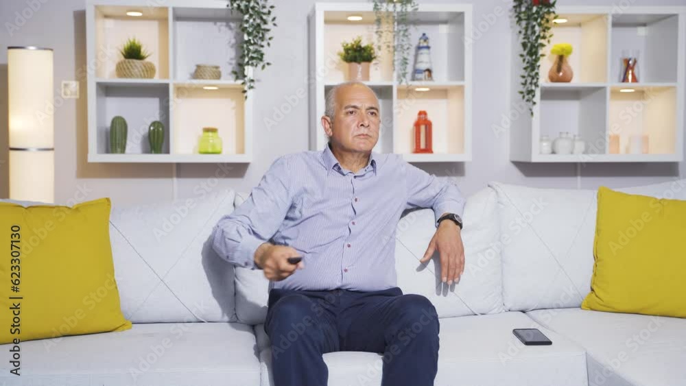 The old man watching TV likes and approves the news he sees. The old man watching TV likes and approves the news he sees.