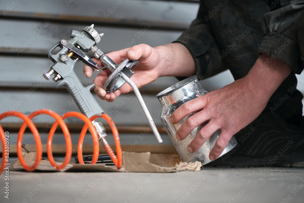 Spray gun work tool and painter hand close up background. Spray gun work tool and painter hand close up background.