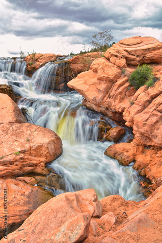 Gunlock Falls State Park Reservoir waterfall views, Utah by St George. 2023 record snowpack spring run off over desert erosion sandstone. Utah, USA.