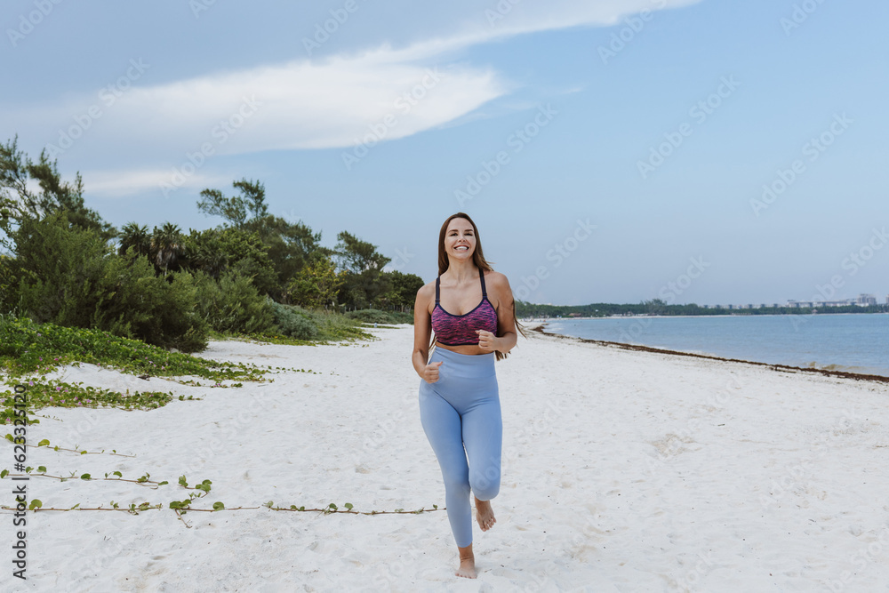 Latin woman running at caribbean beach in Mexico Latin America, hispanic female Latin woman running at caribbean beach in Mexico Latin America, hispanic female