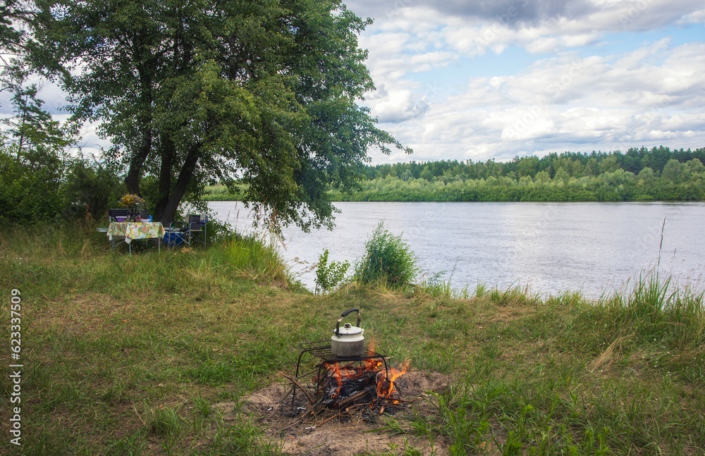 Fototapeta premium Summer vacation on the river bank with a bonfire