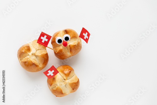 The first august bread buns baked to celebrate national holiday of Switzerland decorated with swiss flag