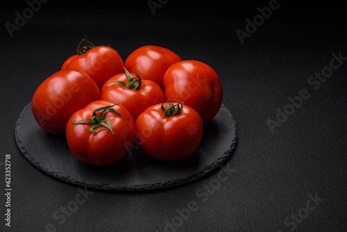 Delicious fresh juicy tomatoes on a dark concrete background