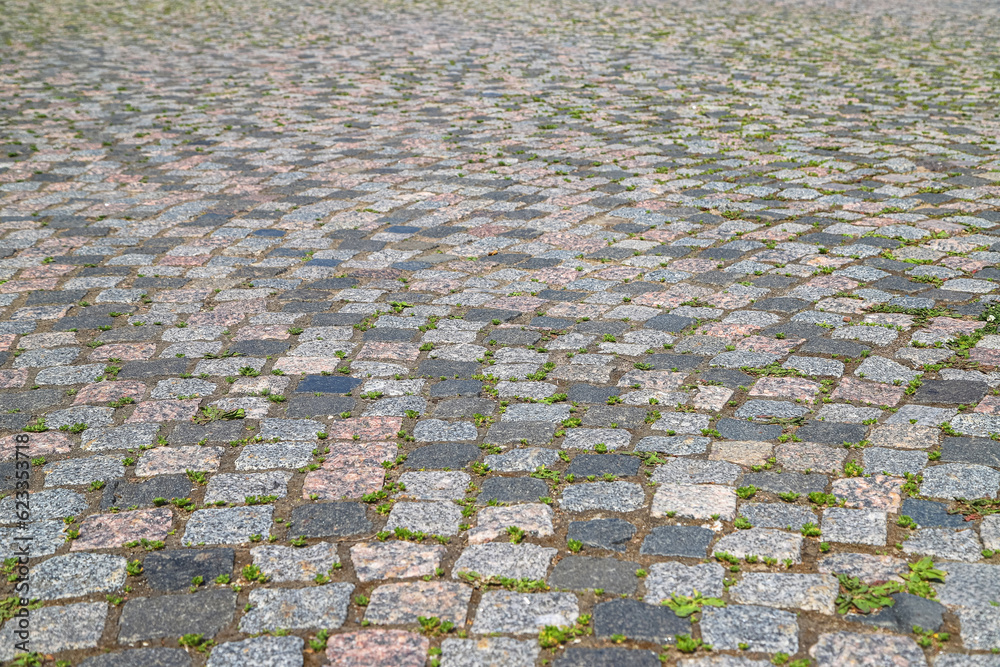 Fototapeta premium An old stoneblock pavement cobbled in an arc pattern with granite blocks. Photo in perspective view with selective focus