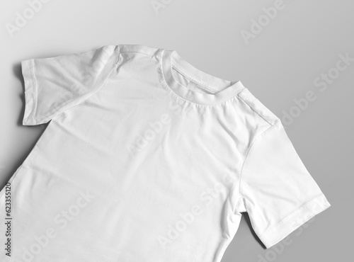 Mockup of white children's t-shirt close-up, wear with a round neck, label, close-up, diagonal presentation, front view.