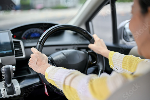 Close-up image of a happy Asian senior lady driving a car. Transportation, automobile