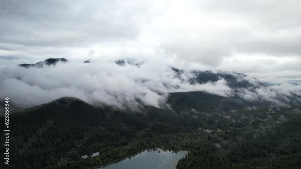 Aerial drone view of Rattlesnake Ridge in Seattle, showcasing the river, mountains, and lush green pines, creating a majestic nature scene. Aerial drone view of Rattlesnake Ridge in Seattle, showcasing the river, mountains, and lush green pines, creating a majestic nature scene.