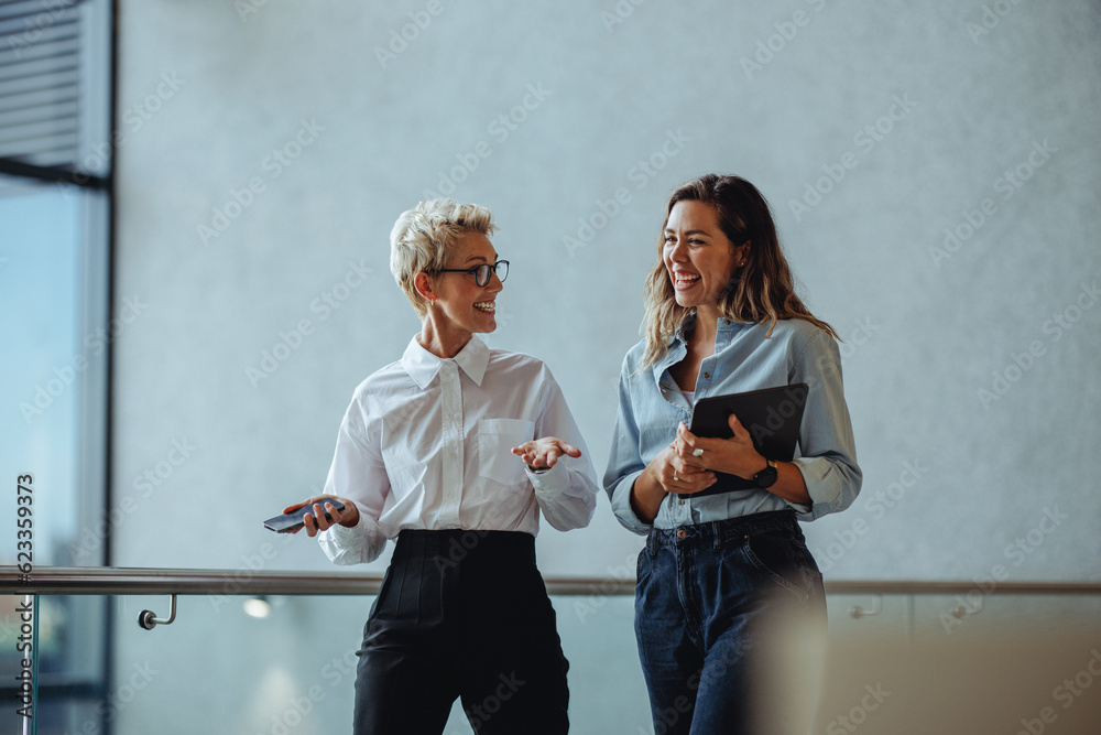 © Jacob Lund - Successful business women having a discussion as they walk through a corporate office