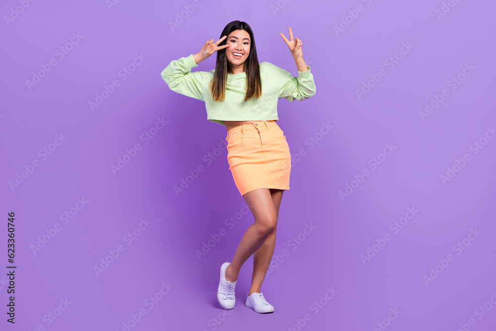 Full length photo of nice funky girl dressed green sweatshirt showing v-sign cover eye isolated violet color background