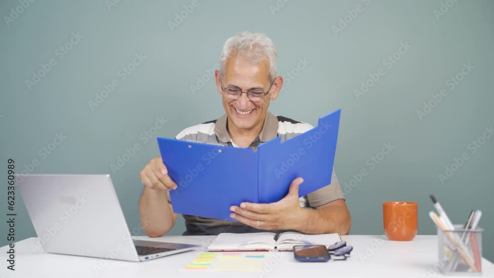 The man examining the files approves the files with his head. The man examining the files approves the files with his head.