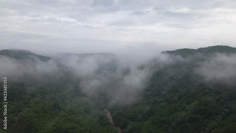Clouds Over valley of Garo Hills In Meghalaya, India. Misty fog blowing over tree forest. Aerial footage of rain forest on the mountain hills at misty day. Morning monsoon flying through Khasi Hills