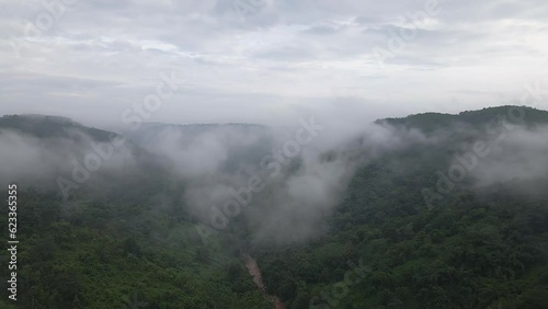 Clouds Over valley of Garo Hills In Meghalaya, India. Misty fog blowing over tree forest. Aerial footage of rain forest on the mountain hills at misty day. Morning monsoon flying through Khasi Hills photo