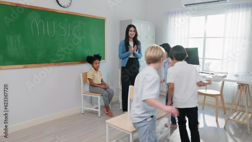 Group of adorable school kids playing active games with teacher in classroom on summer at elementary school. independent and relax activities concept