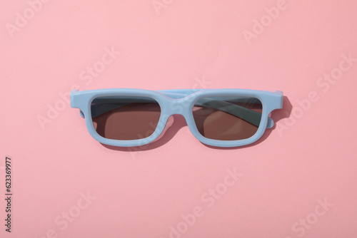 Blue glasses with thinned lenses on light pink background