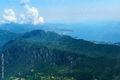 beautiful view of the coast of Montenegro from the height of an airplane flight, mountains and sea, blue sky with soft clouds, the concept of travel