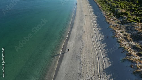 Couple walking along Woodman Point Beach, Perth City suburbs in Western Australia. Aerial drone view