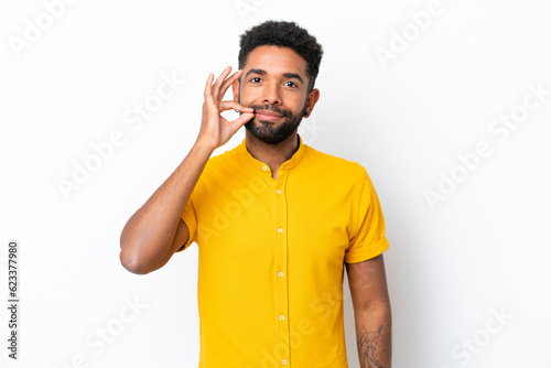 Young Brazilian man isolated on white background showing a sign of silence gesture