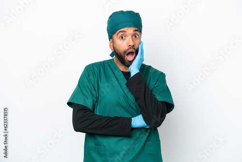 Surgeon Brazilian man in green uniform isolated on white background surprised and shocked while looking right