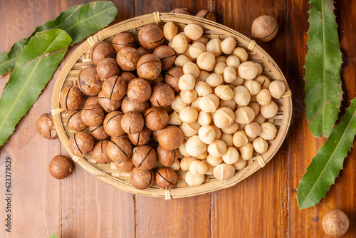 Roasted Macadamia nut in wooden plate on wooden background.