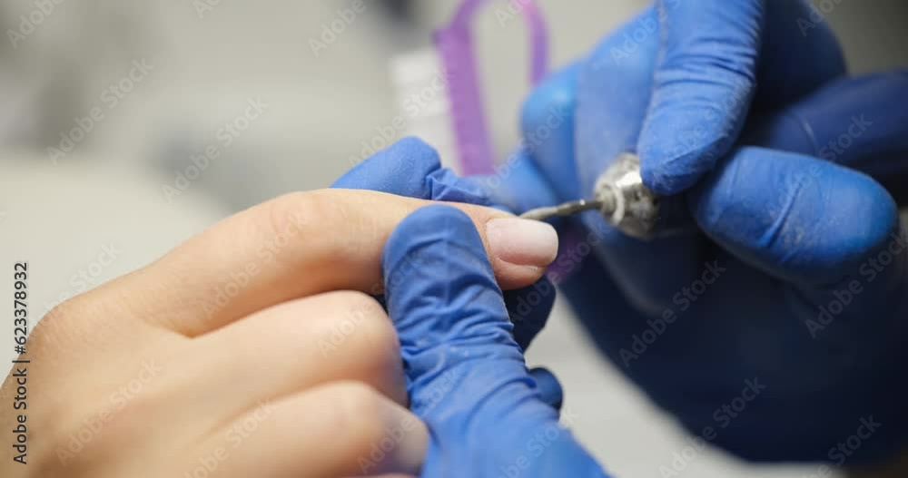 Manicurist processes female nails with a file, close-up. Hygiene procedure in the salon, nail shape Manicurist processes female nails with a file, close-up. Hygiene procedure in the salon, nail shape