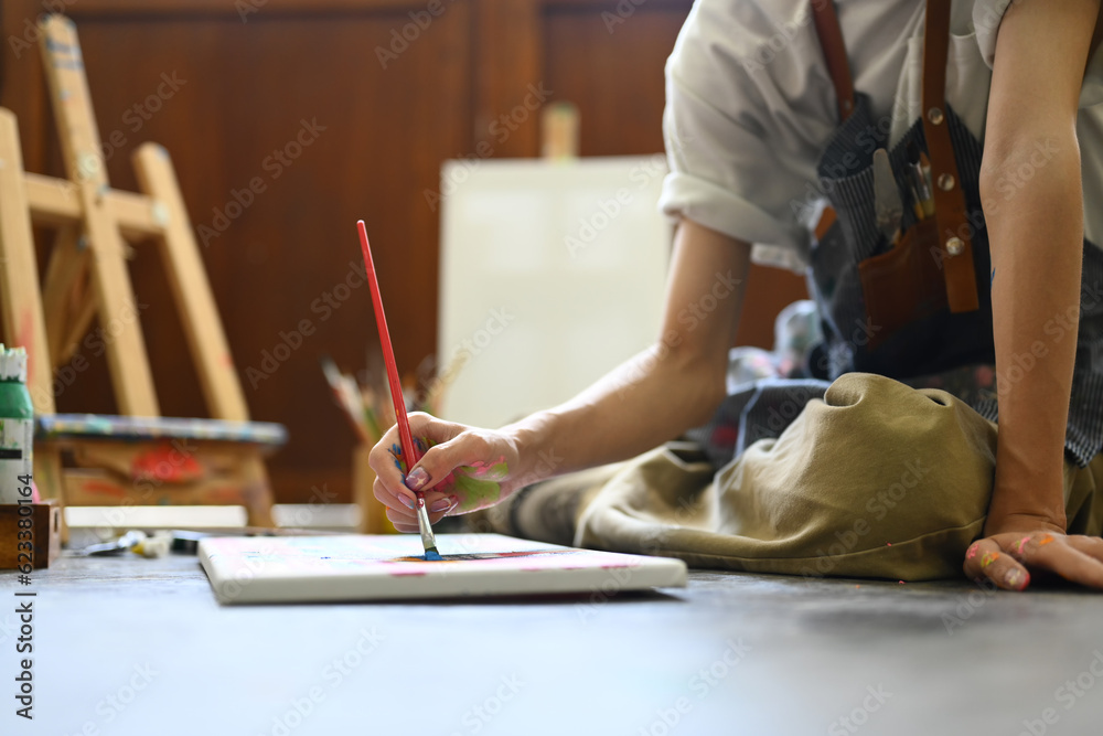 Fototapeta premium Art, education, creativity and people concept. Asian student man painting on canvas with watercolors at art class