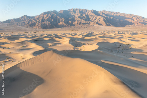 Scenic view on natural ripple sand pattern during sunrise at. Morning desert. Top down view of sand dunes  aerial. Global warming