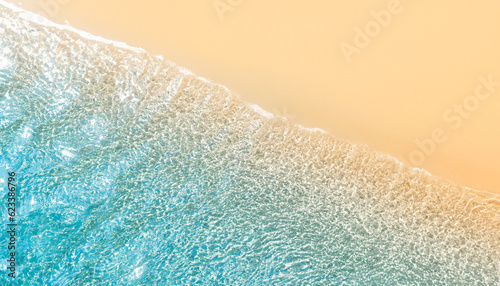 abstract sand beach from above with light blue water wave and sun lights summer background
