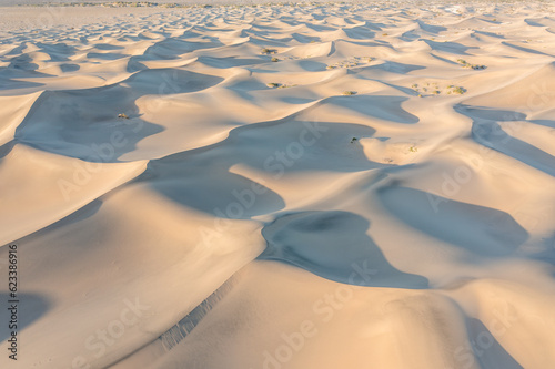 Scenic view on natural ripple sand pattern during sunrise at. Morning desert. Top down view of sand dunes, aerial. Global warming