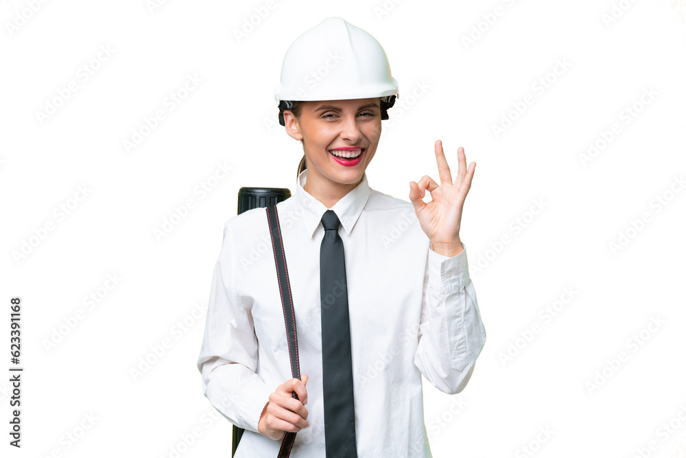 Young architect woman with helmet and holding blueprints over isolated background showing ok sign with fingers Young architect woman with helmet and holding blueprints over isolated background showing ok sign with fingers